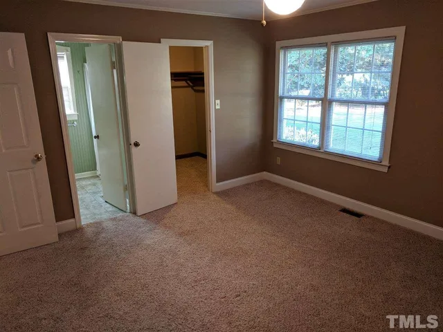 an empty room with windows and closet