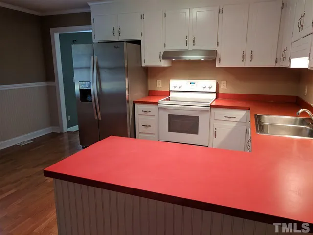 a kitchen with stainless steel appliances a refrigerator sink and cabinets