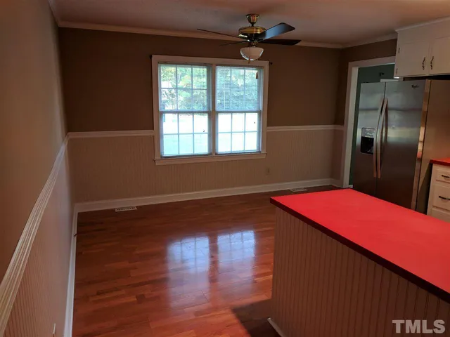 a kitchen with stainless steel appliances kitchen island granite countertop a refrigerator a sink dishwasher and wooden floor