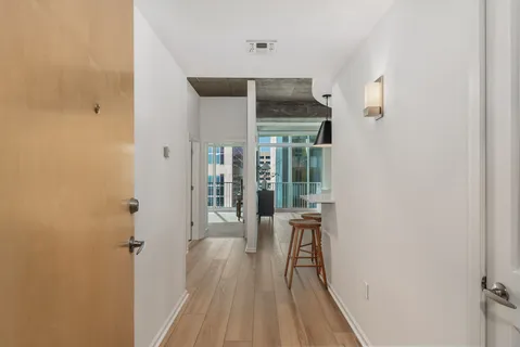 a view of a hallway with wooden floor and entryway