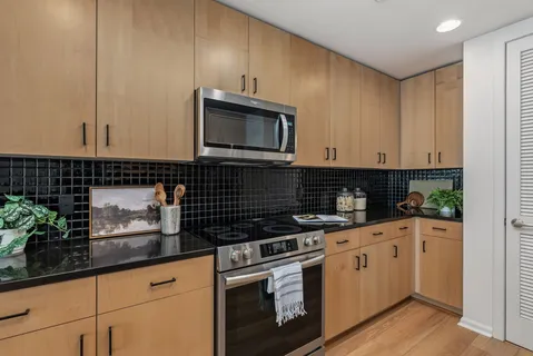 a kitchen with stainless steel appliances granite countertop a sink a stove and cabinets