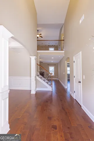 an empty room with wooden floor chandelier and windows