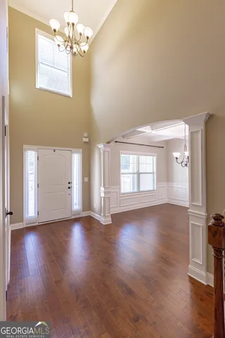 an empty room with wooden floor fireplace and windows