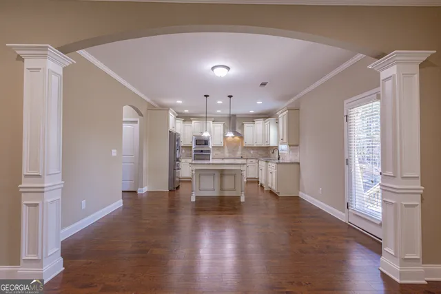 a kitchen with granite countertop white cabinets and stainless steel appliances