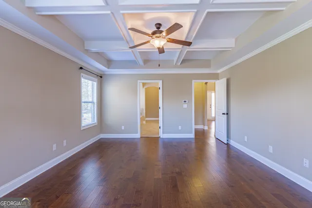 an empty room with a ceiling fan and a window