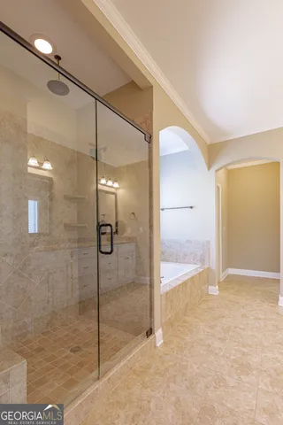 a bed sitting in a bedroom next to a window and a chandelier