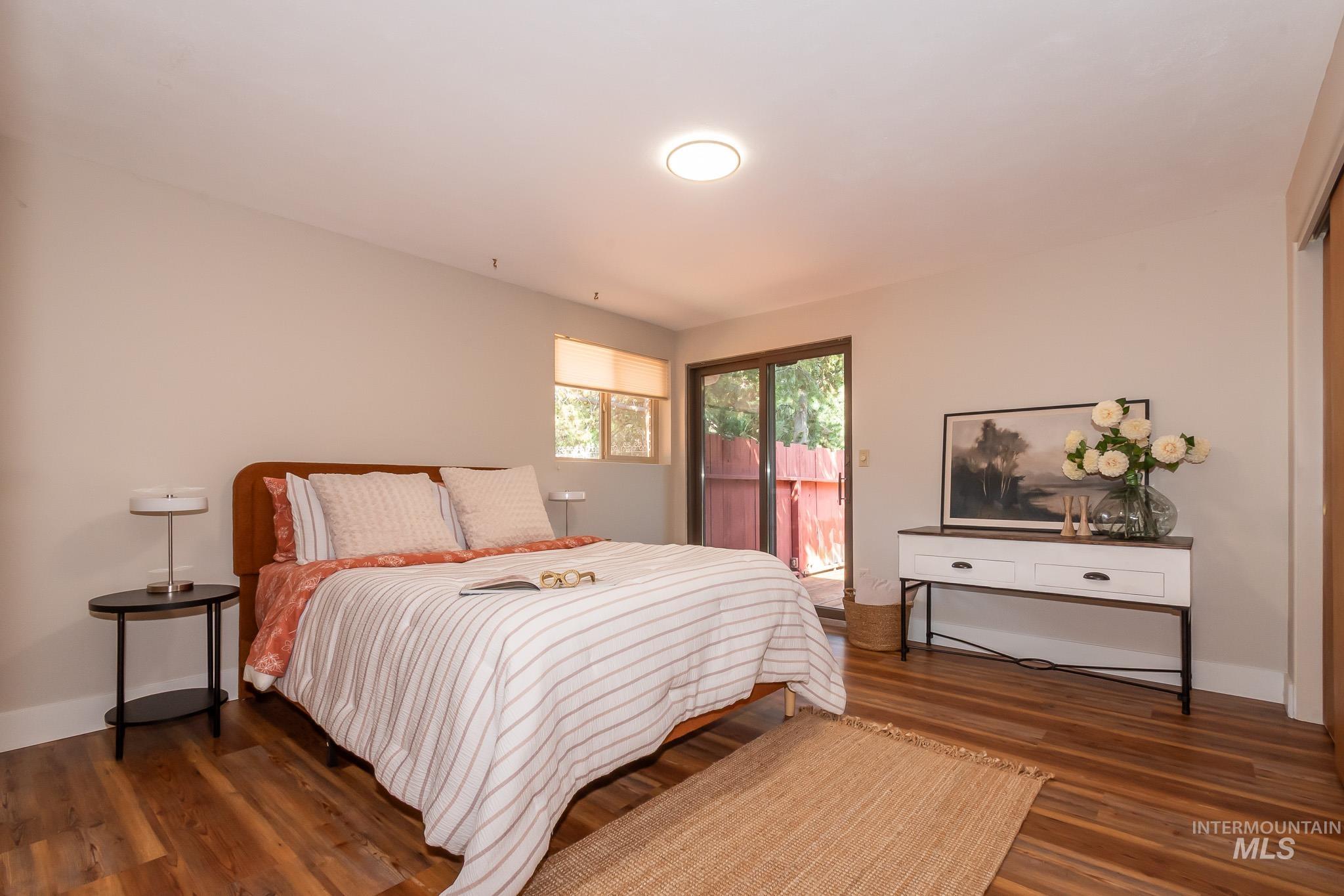 3706 West Clement Road Boise, ID 83704 - Photo 21 of 36 Bright primary bedroom showcasing warm wood-finish flooring, recessed ceiling lighting, and glass sliding doors opening to outdoor space