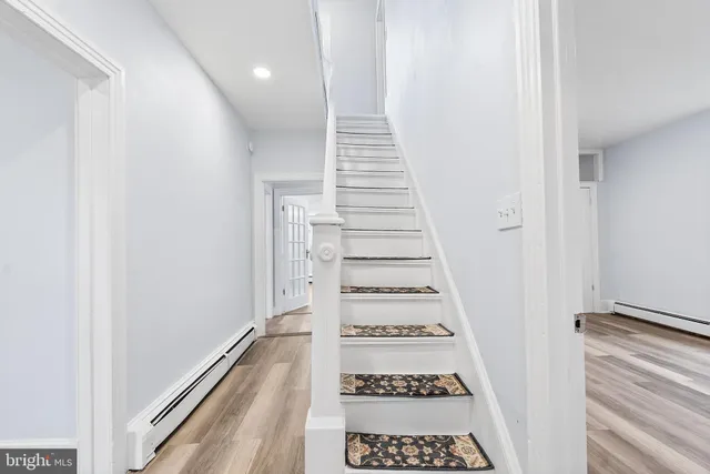 a view of a hallway with wooden floor and entryway