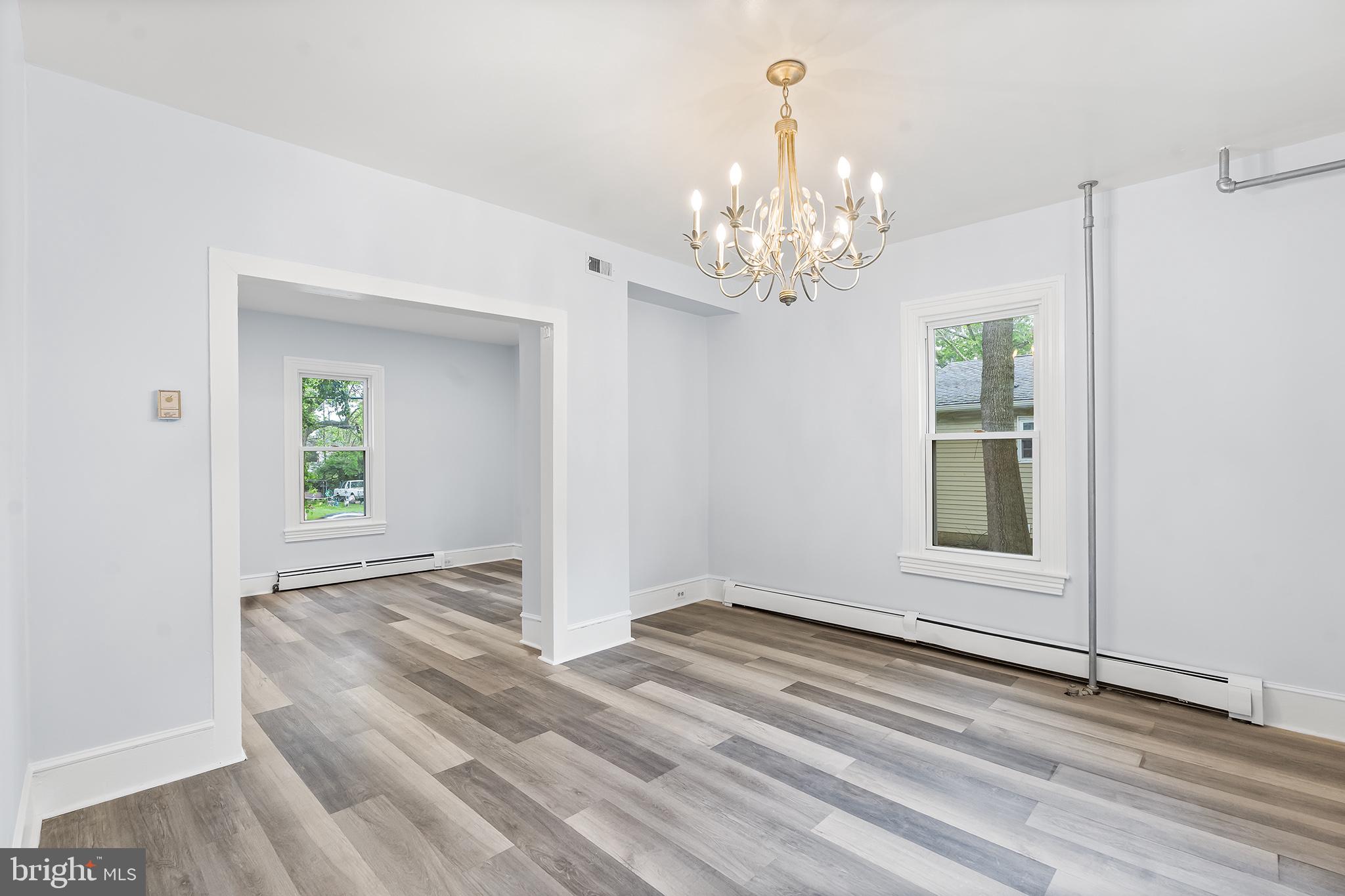 131 West Clinton Street Clayton, NJ 08312 - Photo 20 of 41 an empty room with wooden floor chandelier and windows