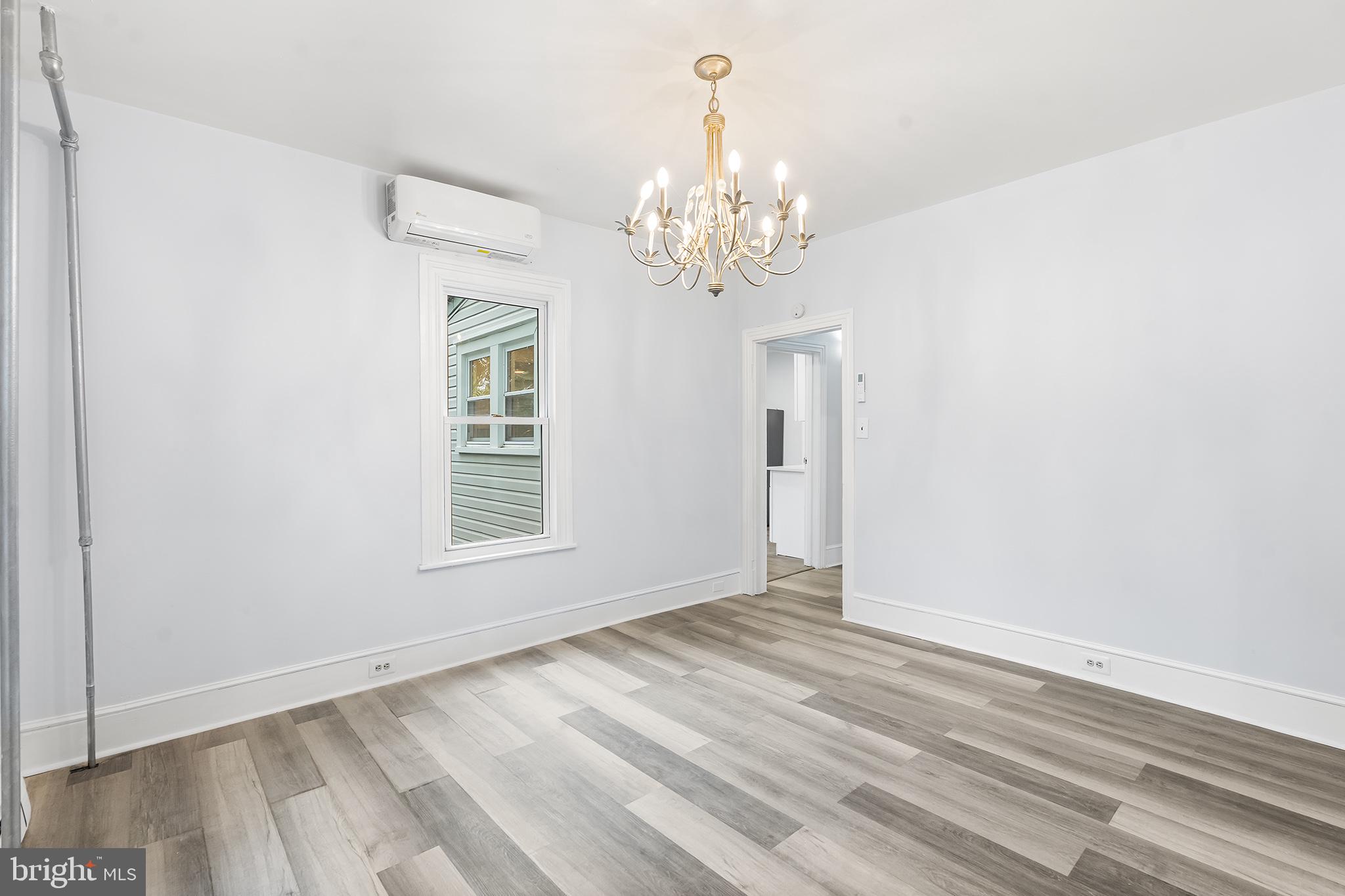131 West Clinton Street Clayton, NJ 08312 - Photo 21 of 41 a view of an empty room with wooden floor and a window