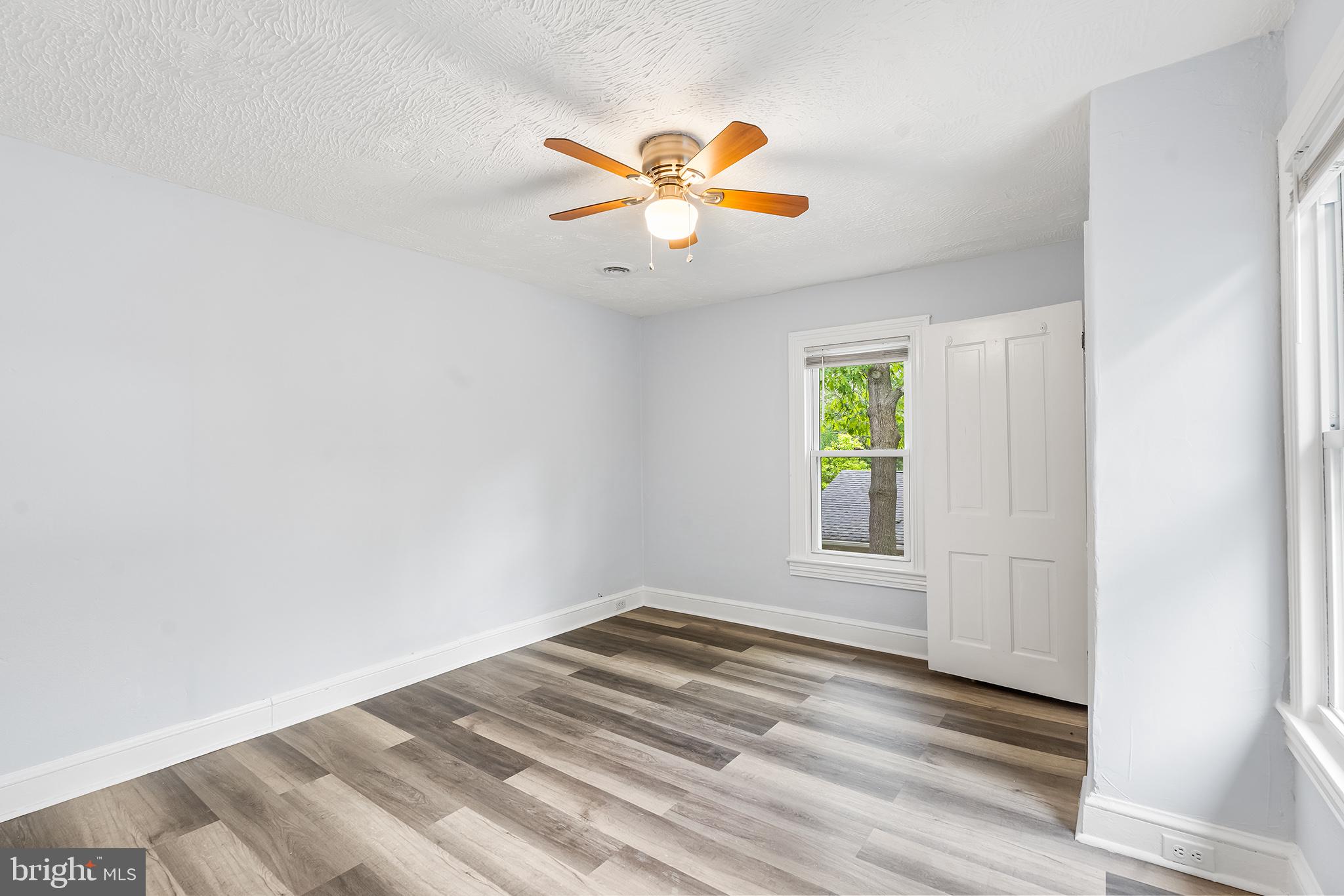 131 West Clinton Street Clayton, NJ 08312 - Photo 27 of 41 a view of an empty room with window and wooden floor