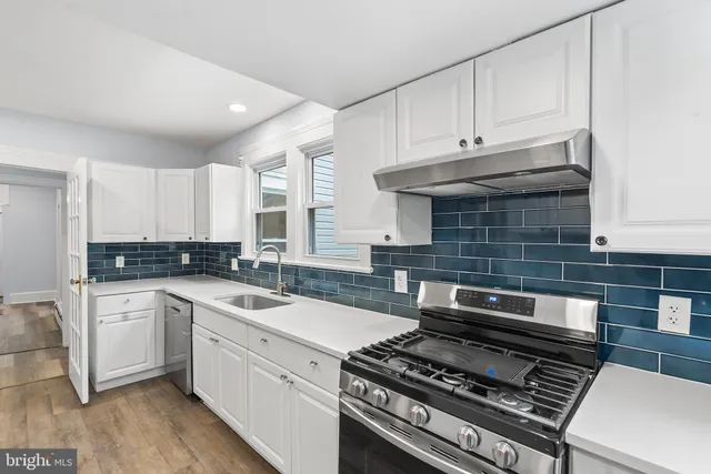 a kitchen with a stove and white cabinets