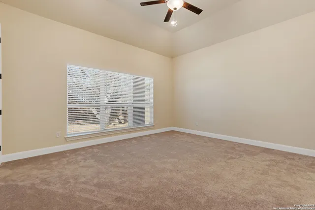 an empty room with windows and fan