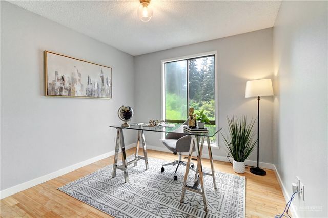 a view of a workspace with furniture and a window
