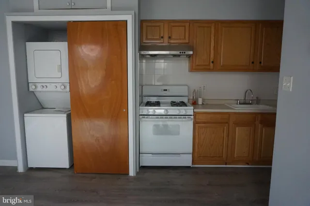 a utility room with wooden floor washer and dryer