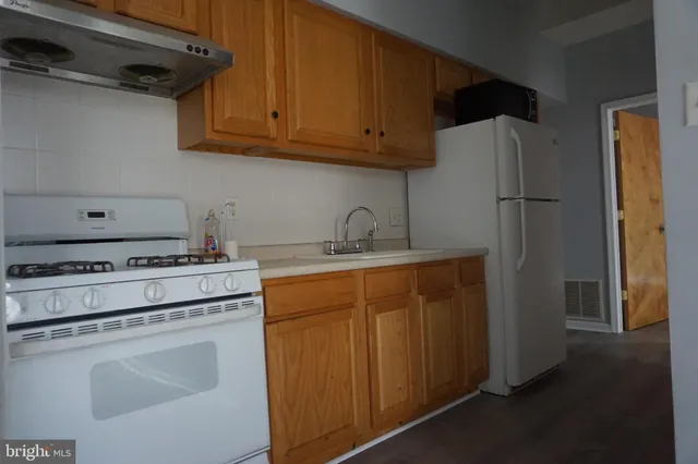 a kitchen with stainless steel appliances granite countertop a refrigerator stove and sink