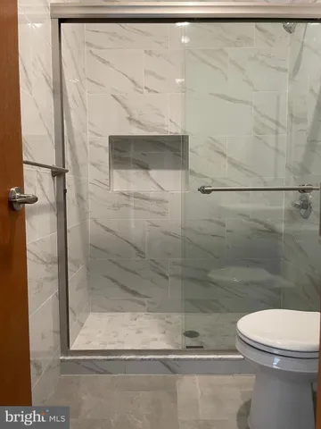 a bathroom with a toilet and a shower