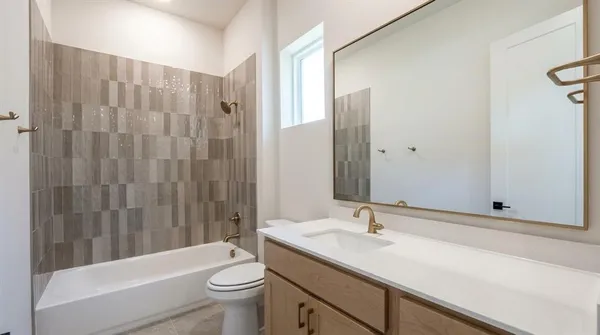 a bathroom with a granite countertop sink a toilet and shower
