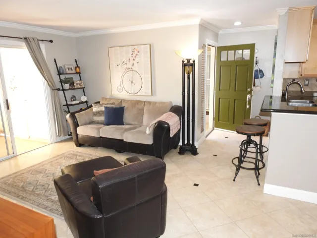 a kitchen with stainless steel appliances granite countertop a refrigerator a stove a sink dishwasher and a stove with the view of living room