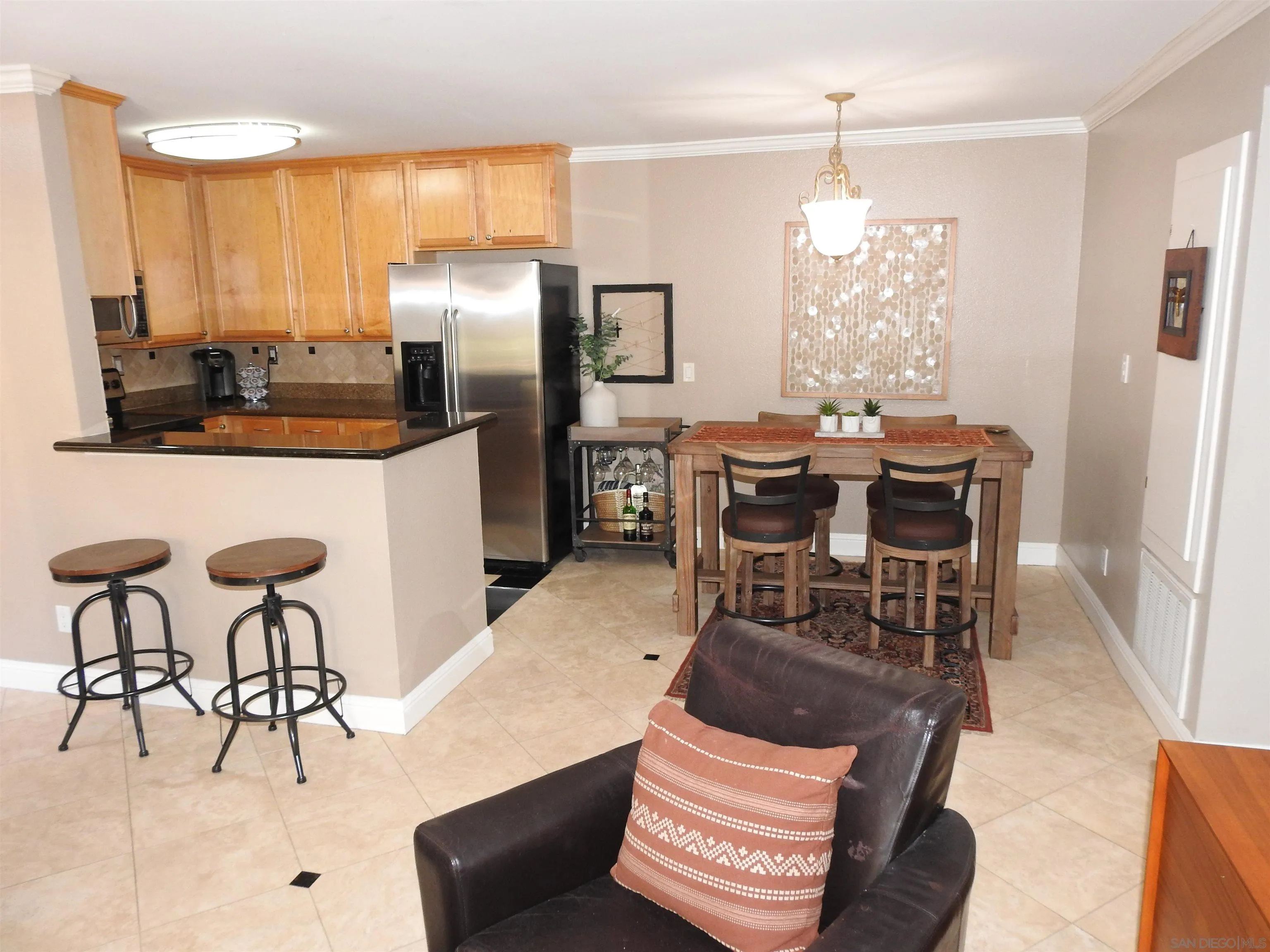 3515 Grove Street, Unit 108 Lemon Grove, CA 91945 - Photo 2 of 58 a kitchen with stainless steel appliances kitchen island granite countertop a dining table chairs and a refrigerator