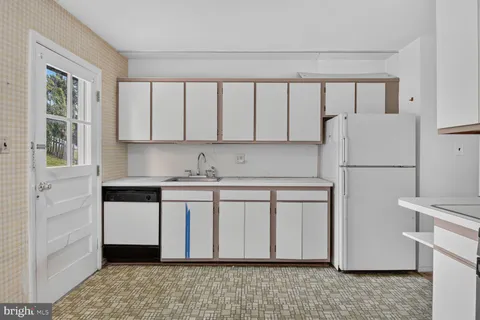 a kitchen with stainless steel appliances granite countertop a refrigerator sink and white cabinets