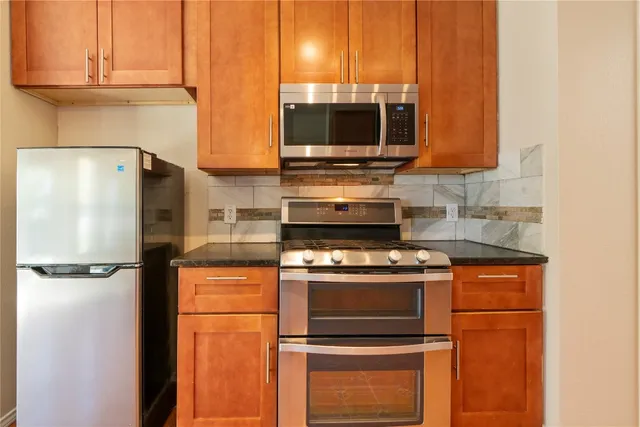 a kitchen with stainless steel appliances granite countertop a refrigerator stove and microwave
