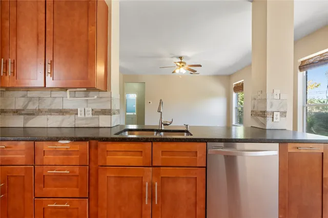 a kitchen with stainless steel appliances granite countertop a sink a counter space and cabinets