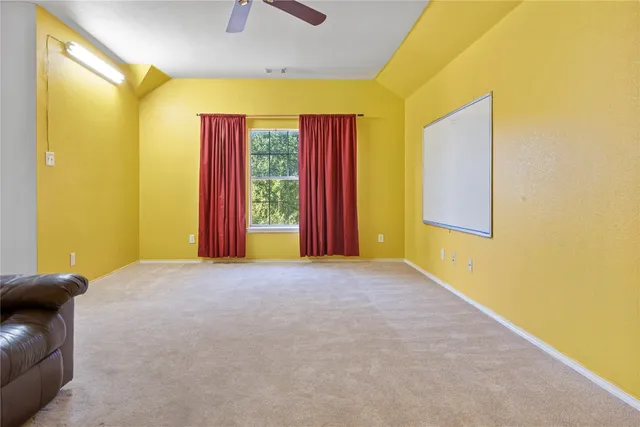 a view of a room with a window and a ceiling fan