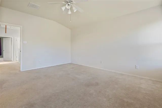 an empty room with a chandelier fan