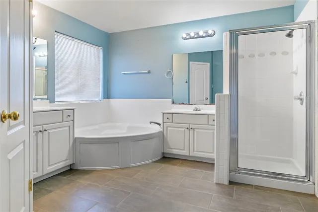 a spacious bathroom with a tub sink and mirror