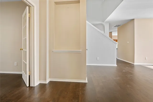 a view of an empty room with wooden floor