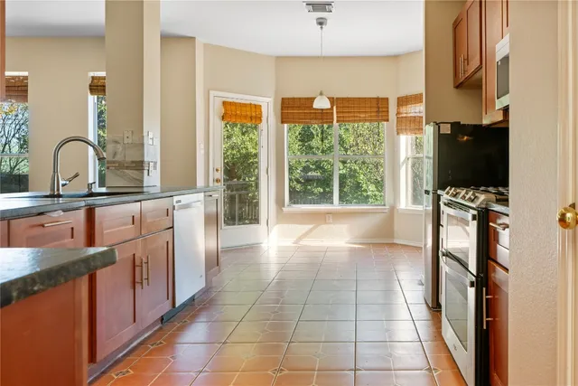 a kitchen with stainless steel appliances a sink a stove top oven a counter space and cabinets