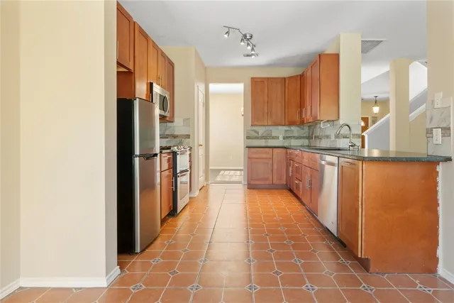 a kitchen with stainless steel appliances granite countertop a refrigerator and a stove