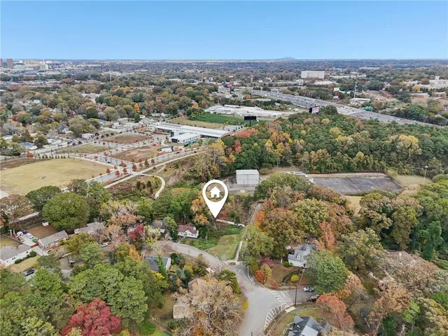an aerial view of a residential houses with outdoor space and trees