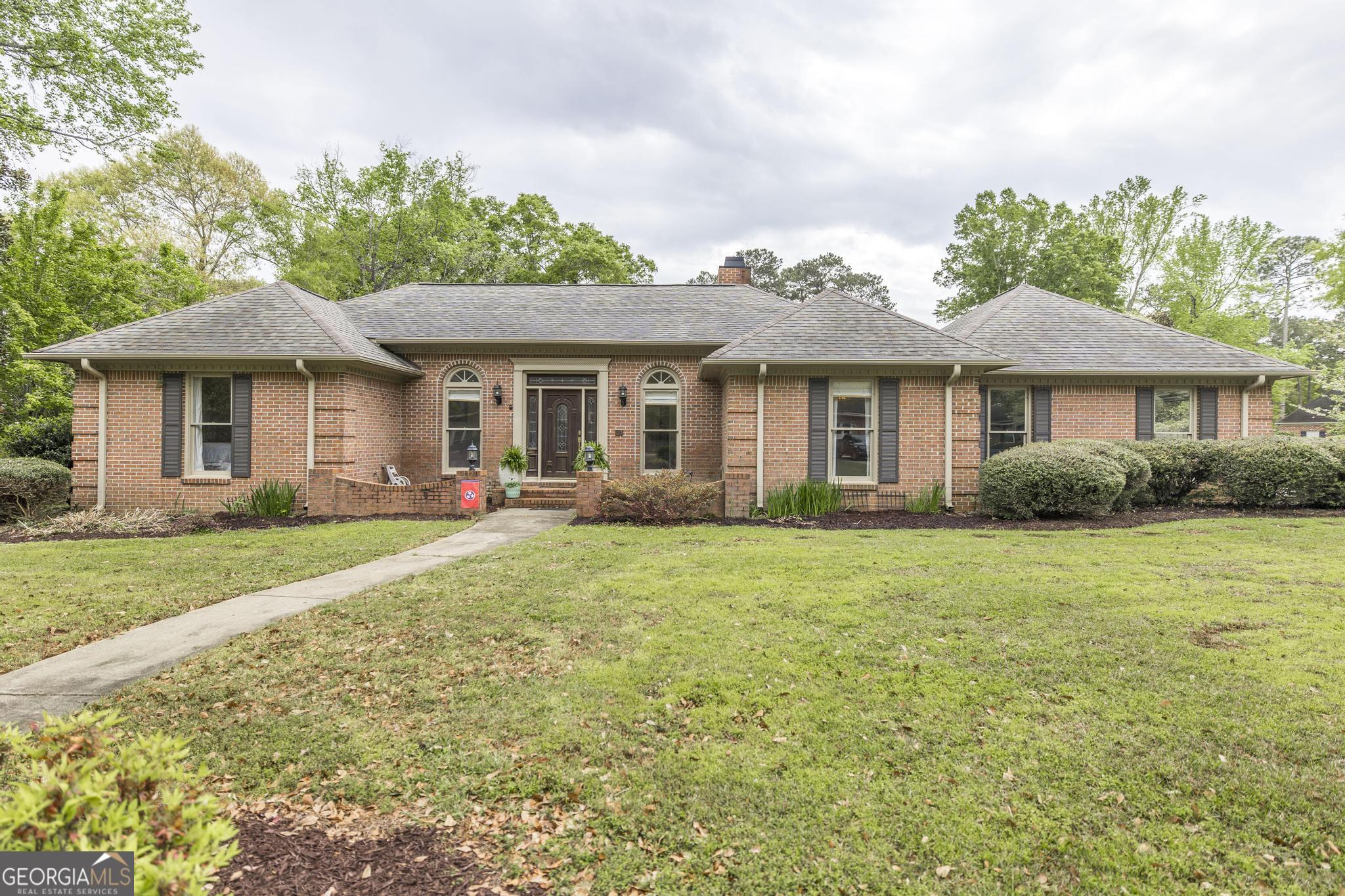 a front view of a house with a garden