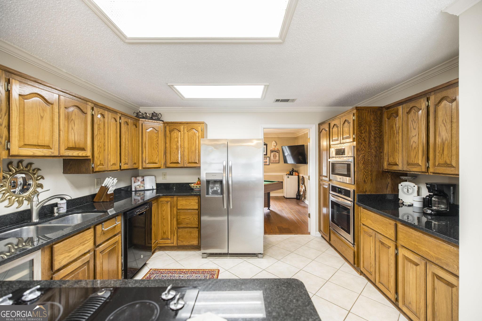 108 Bunkers Trail Warner Robins, GA 31088 - Photo 14 of 34 a kitchen with stainless steel appliances granite countertop a refrigerator a stove top oven and sink
