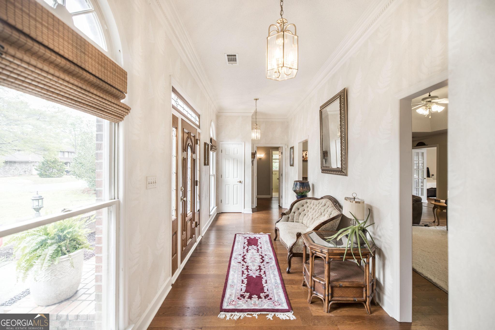 108 Bunkers Trail Warner Robins, GA 31088 - Photo 8 of 34 a view of a hallway with furniture and a chandelier
