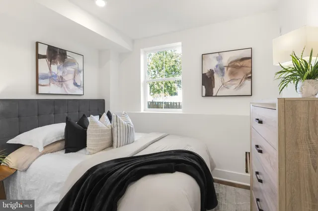 a bedroom with bed and wall painting with wooden floor