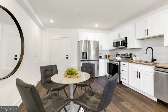 a kitchen with stainless steel appliances a dining table and chairs