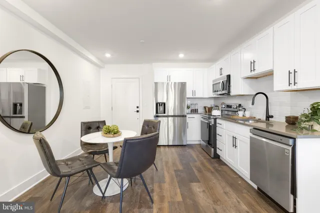 a kitchen with a dining table chairs and a stove top oven