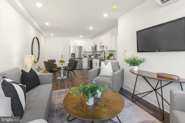 a living room with furniture a dining table and a potted plant