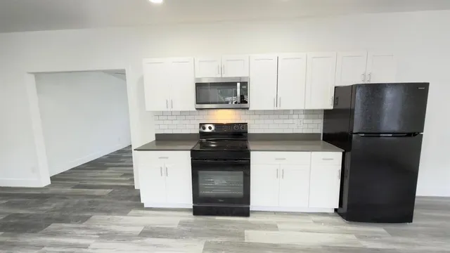 a kitchen with a refrigerator and a stove