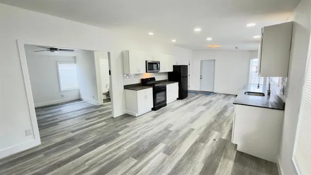 a view of kitchen with refrigerator stove and wooden floor