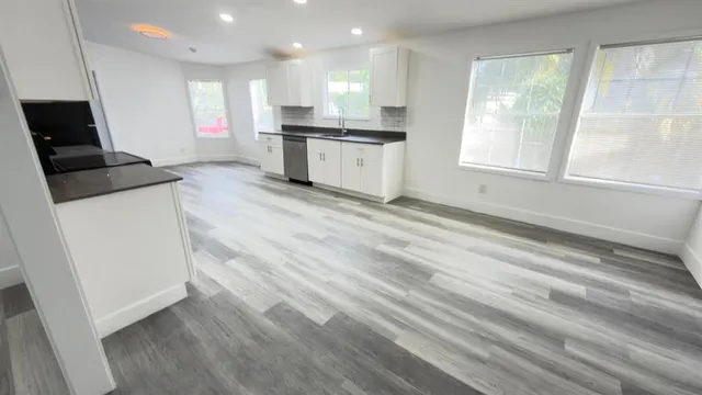 a view of kitchen with wooden floor and electronic appliances