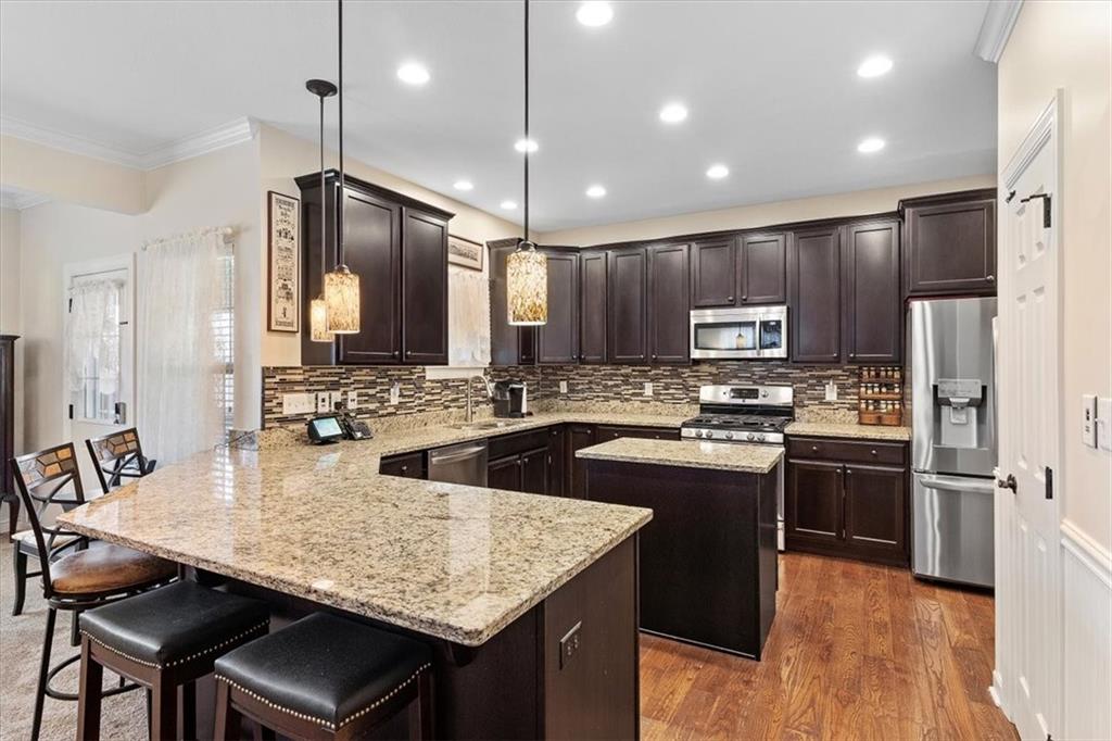 358 Wealdstone Road Cranberry Township, PA 16066 - Photo 12 of 46 a kitchen with stainless steel appliances granite countertop a kitchen island hardwood floor sink stove dining table and chairs