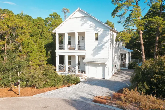 a front view of a house with a yard and trees
