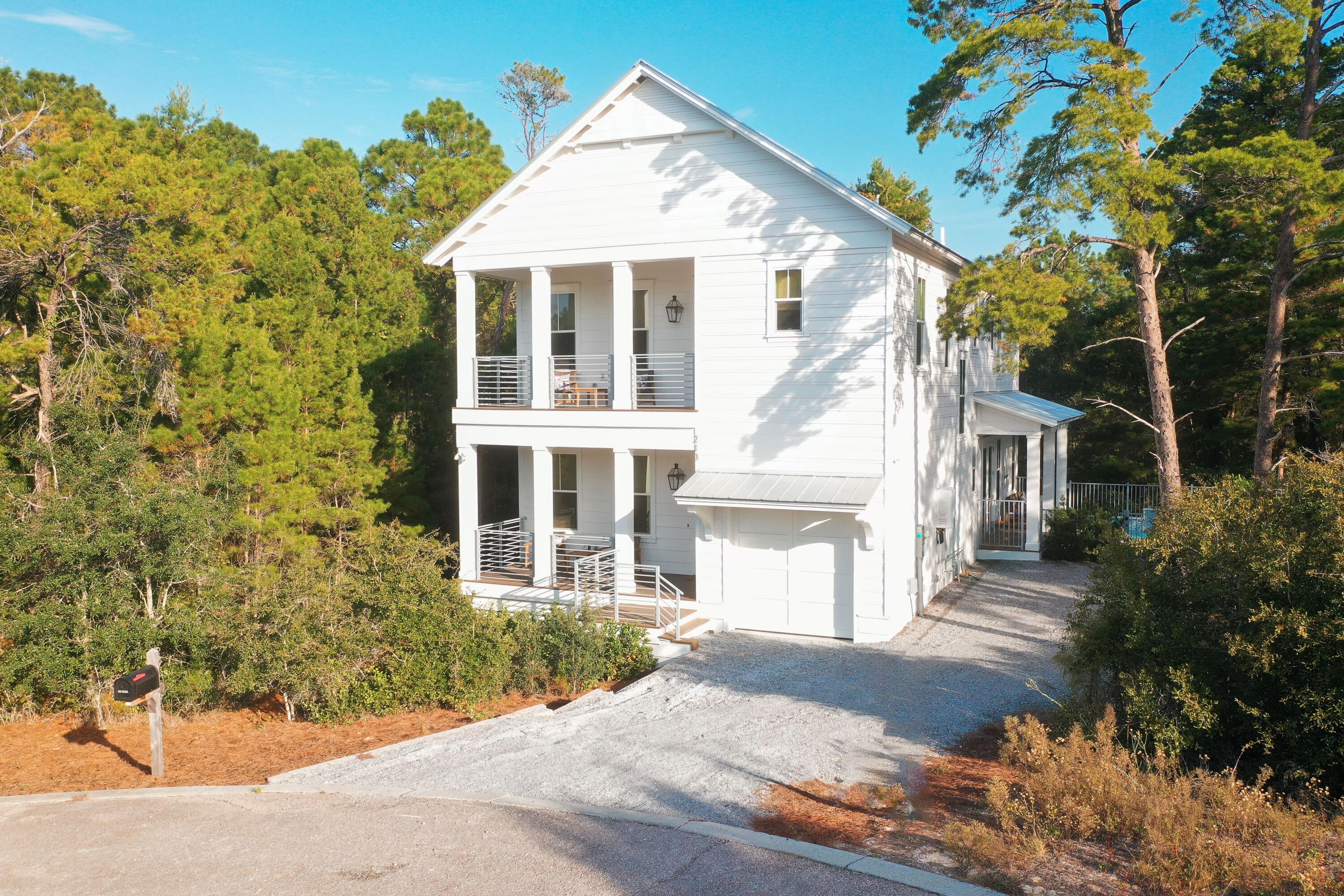 213 Spotted Dolphin Road Santa Rosa Beach, FL 32459 - Photo 2 of 72 a front view of a house with a yard and garage