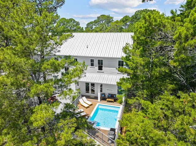 a view of a house with pool and sitting area