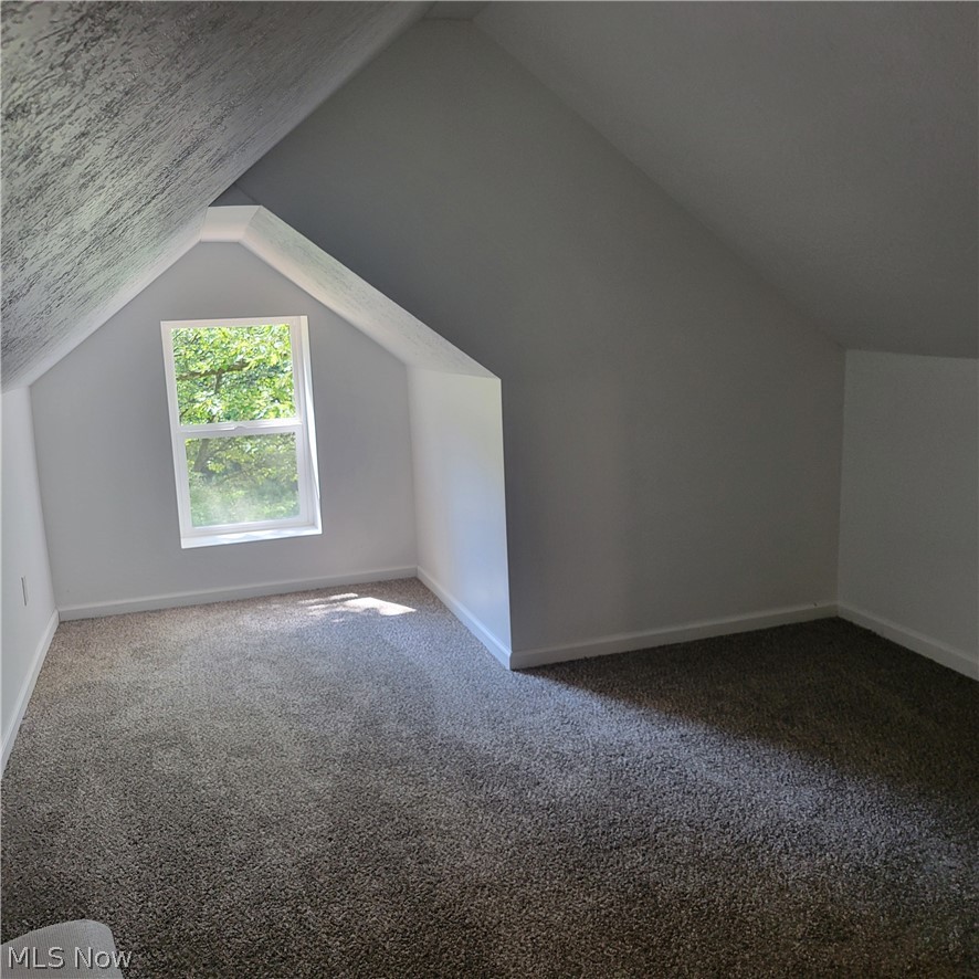 1500 Warner Road Southeast Canton, OH 44707 - Photo 12 of 21 Additional living space with vaulted ceiling and carpet floors