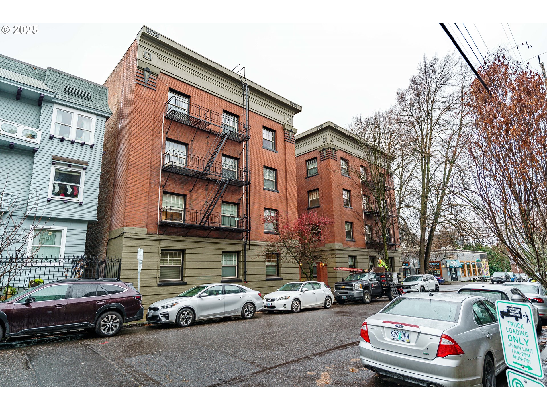 2109 Northwest Irving Street, Unit 114 Portland, OR 97210 - Photo 26 of 29 a front view of a residential apartment building with cars parked